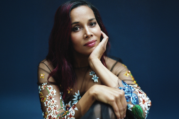 Rhiannon Giddens in a chair with a thoughtful expression on her face