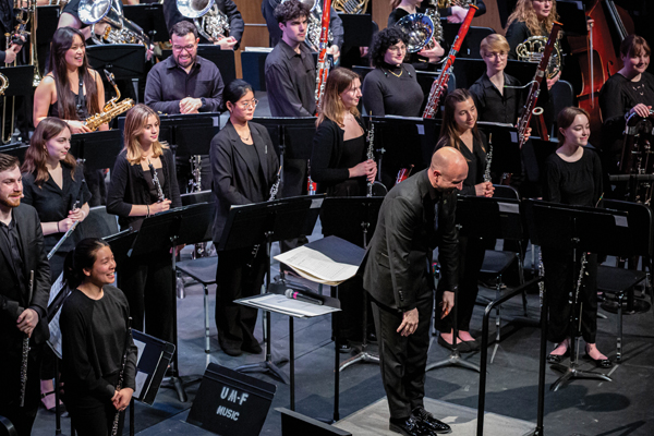 Director Jason K. Fettig takes a bow on stage with the U-M Symphony Band