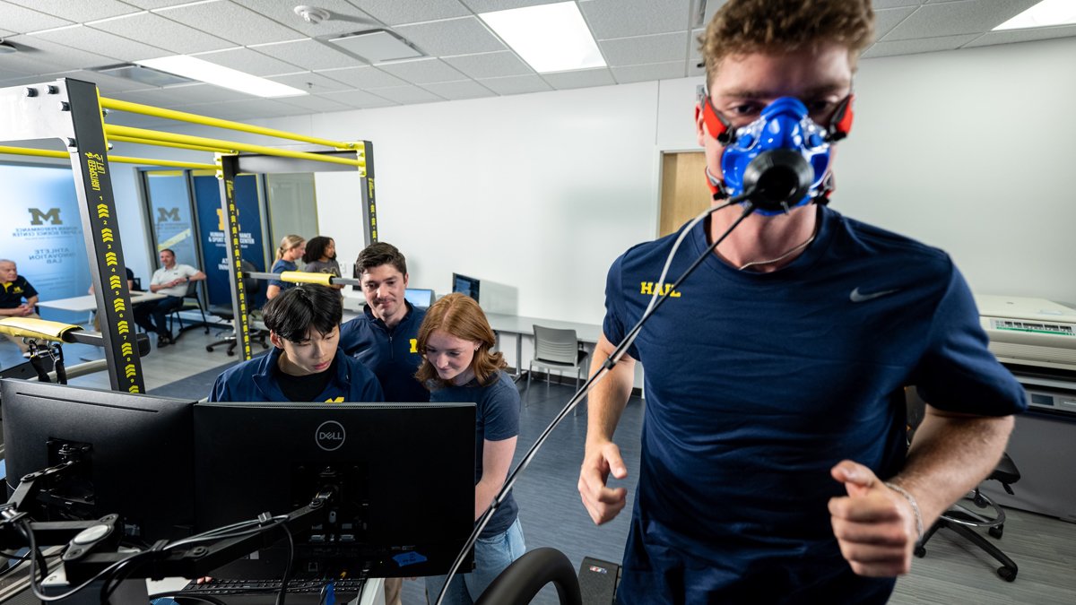 A person running on a treadmill while wearing an activity monitoring mask