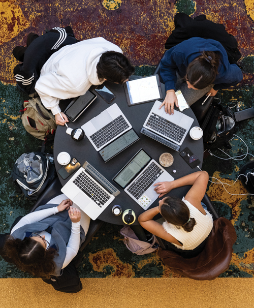 An overhead view of students collaborating with their laptops in the Davidson Winter Garden